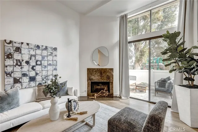 a living room with furniture a fireplace and a large window