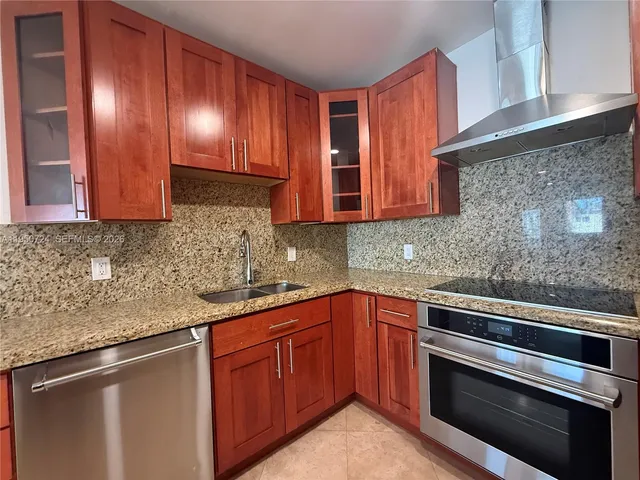 a kitchen with granite countertop a sink and a stove