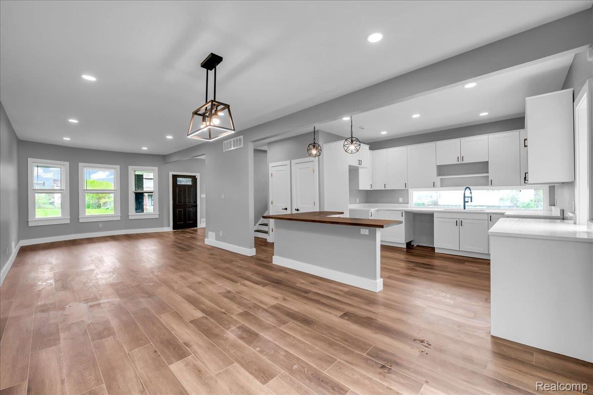 2181 Harding Street Detroit, MI 48214 - Photo 32 of 32 Kitchen featuring open floor plan, a center island, wood counters, white cabinetry, and light wood-style floors