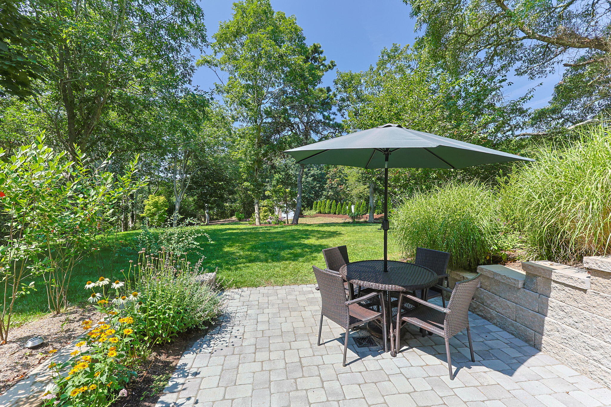 58 Stepping Stones Road Chatham, MA 02633 - Photo 40 of 52 a view of a table and chairs under an umbrella in backyard