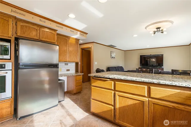 a kitchen with stainless steel appliances granite countertop a refrigerator and a sink