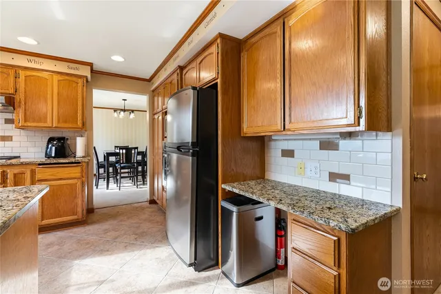 a kitchen with stainless steel appliances granite countertop a stove refrigerator and cabinets