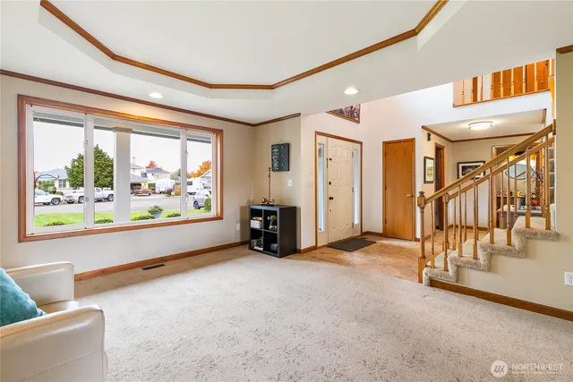 a view of an empty room with window a ceiling fan and front door