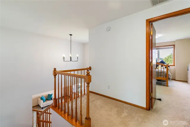 a view of a hallway with wooden floor and stairs
