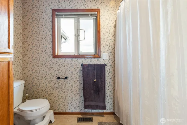 a bathroom with a toilet a sink and a window