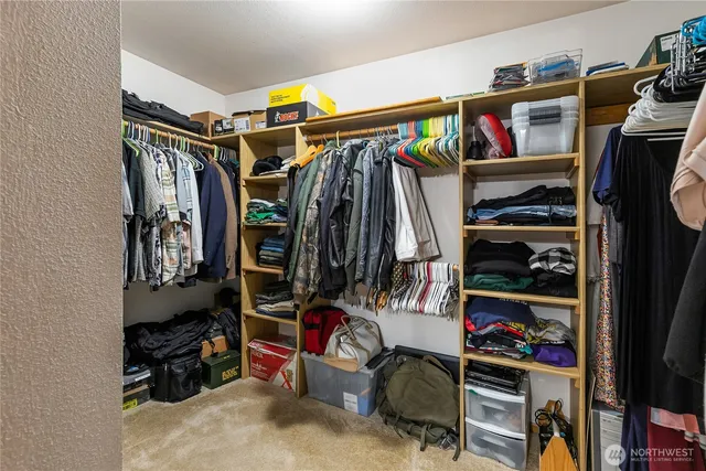 a view of walk in closet with clothes and shoes