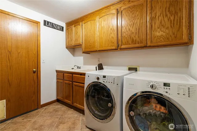 a utility room with sink dryer and washer
