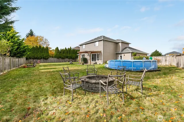 a view of a house with pool and a yard