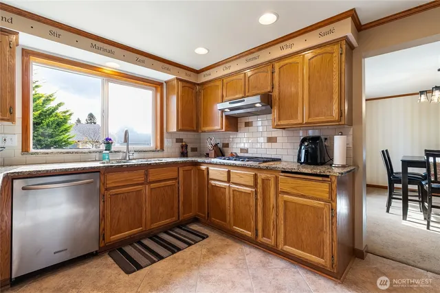 a kitchen with stainless steel appliances granite countertop a stove a sink and a refrigerator