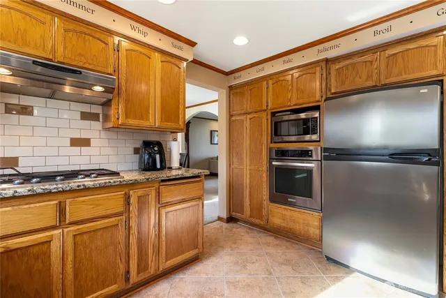 a kitchen with stainless steel appliances granite countertop a refrigerator and a stove