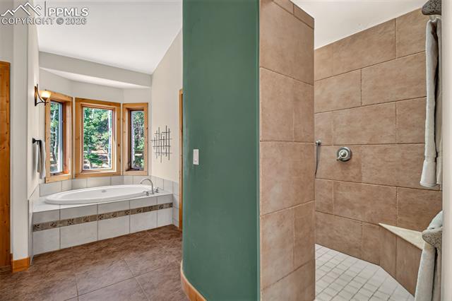 255 Summit Road Manitou Springs, CO 80829 - Photo 30 of 48 5 peice en suite primary bathroom with dual copper sinks surrounded by granite countertops with a stand in shower and better bathtub
