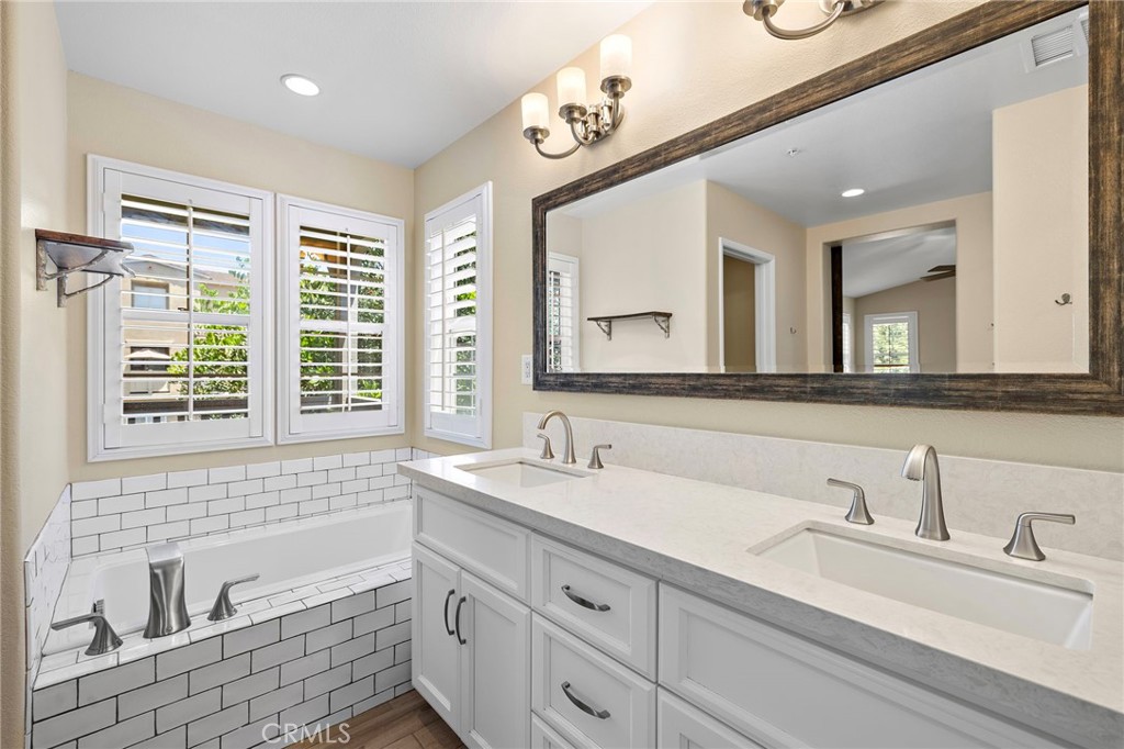 71 Sklar Street Ladera Ranch, CA 92694 - Photo 22 of 55 a bathroom with double vanity sink a mirror and a bathtub