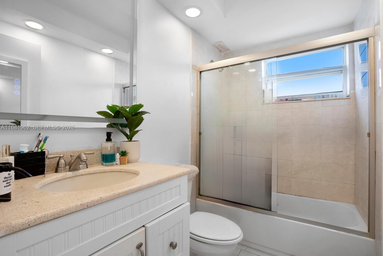 1300 Lincoln Road, Unit A701 Miami Beach, FL 33139 - Photo 14 of 36 a bathroom with a granite countertop sink a toilet and shower
