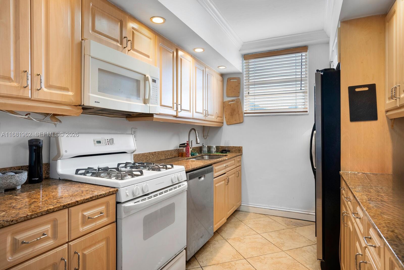 1300 Lincoln Road, Unit A701 Miami Beach, FL 33139 - Photo 10 of 36 a kitchen with stainless steel appliances granite countertop a stove a sink and a microwave