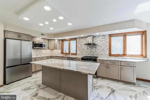 a large kitchen with granite countertop a sink and stainless steel appliances
