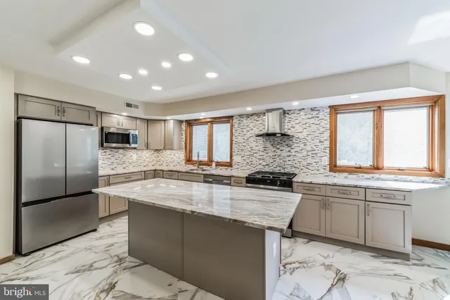 a kitchen with kitchen island granite countertop a stove and a sink