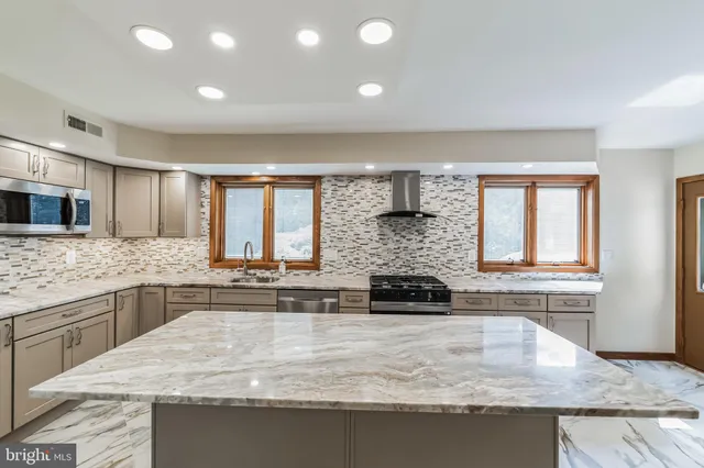 a kitchen with a sink and chairs
