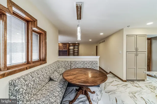 a spacious bedroom with a bed dresser and a table