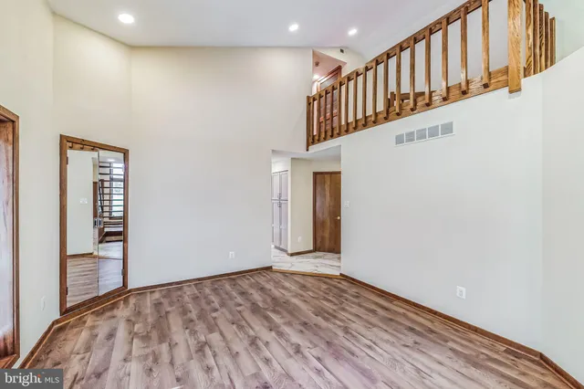 a view of a hallway with wooden floor and staircase