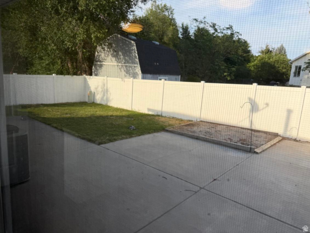 1563 South 600 East Springville, UT 84663 - Photo 29 of 30 Private backyard featuring a white vinyl fence, concrete patio, and a dedicated garden bed