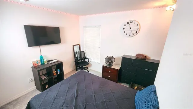 a living room with furniture a flat screen tv and a window