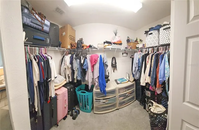 a view of walk in closet with clothes