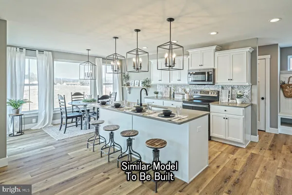 a kitchen with kitchen island granite countertop a sink a counter space appliances and cabinets