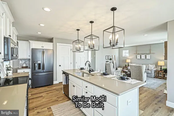 a kitchen with stainless steel appliances kitchen island granite countertop a sink and refrigerator