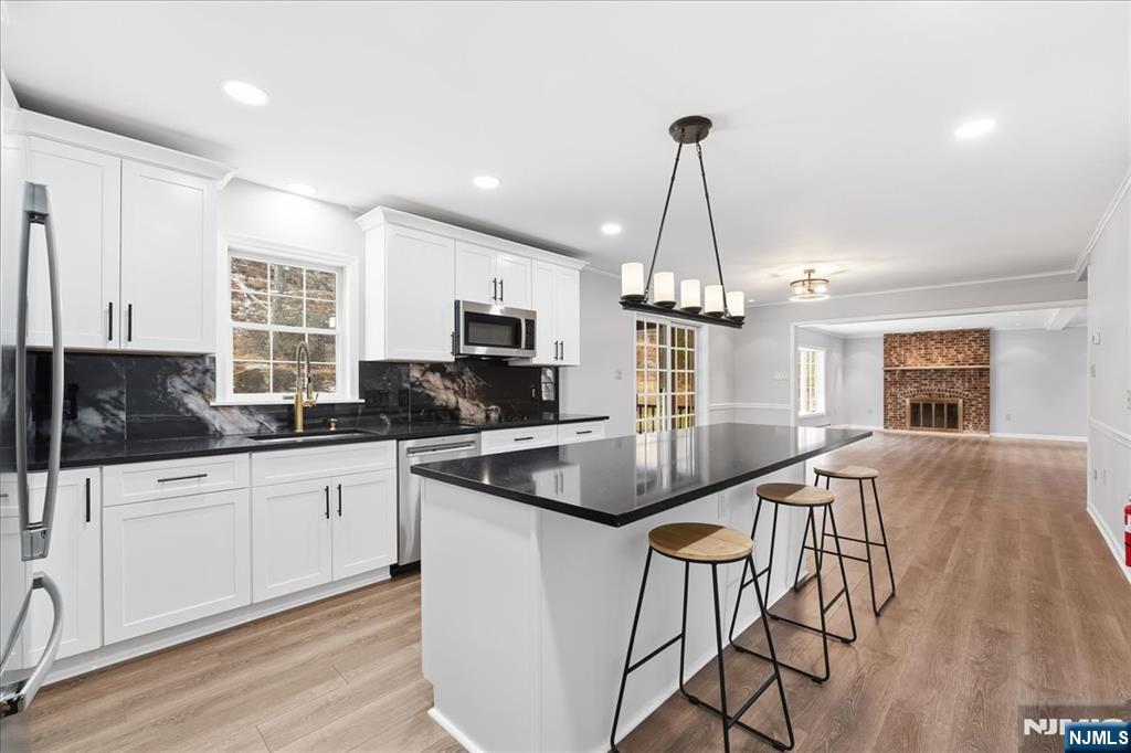 611 Snake Den Road West Milford, NJ 07480 - Photo 4 of 46 a kitchen with stainless steel appliances granite countertop a kitchen island hardwood floor sink stove and granite counter top
