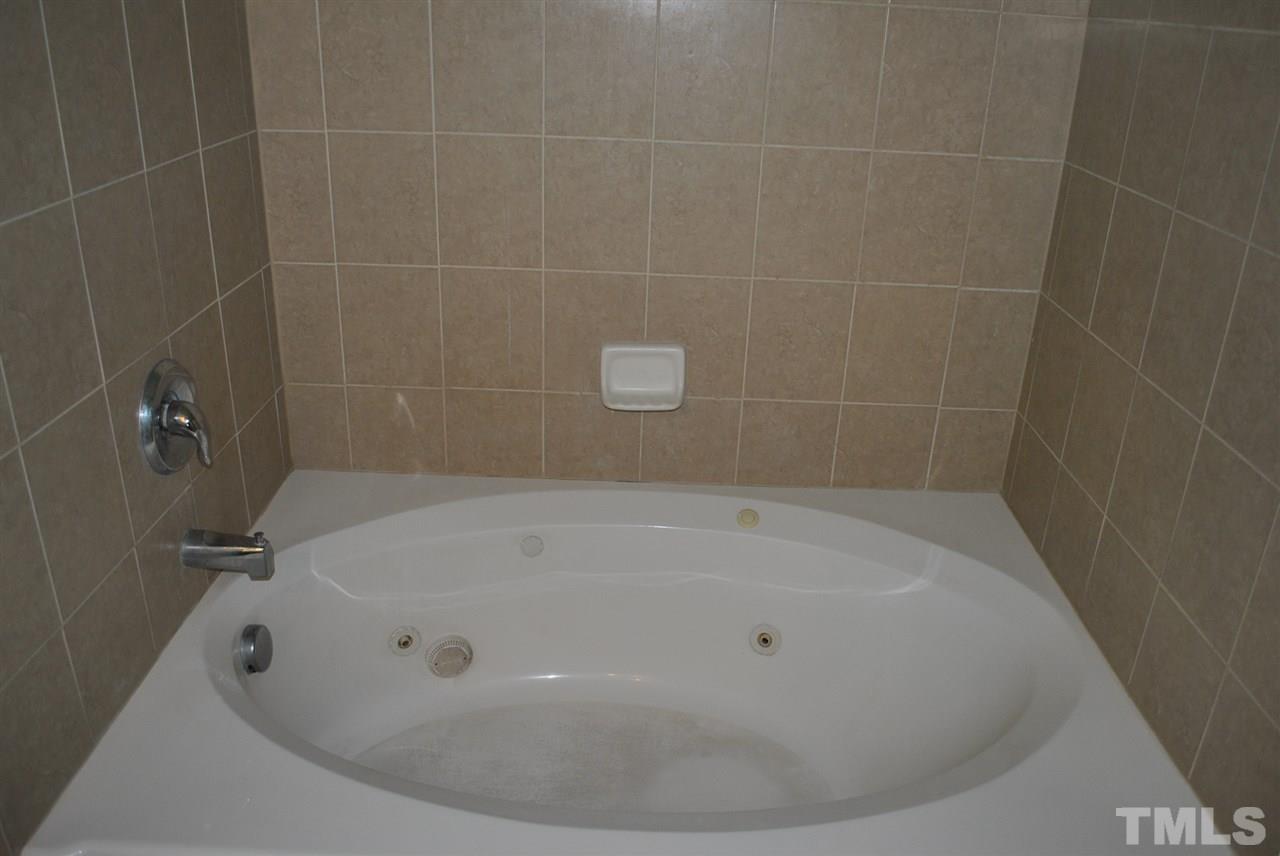 8234 Belneath Court Raleigh, NC 27613 - Photo 14 of 20 a white bath tub sitting in a bathroom and shower
