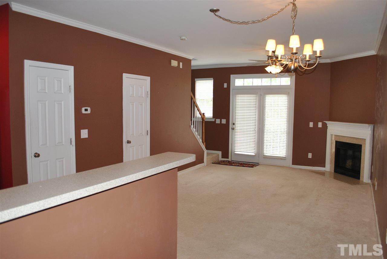 8234 Belneath Court Raleigh, NC 27613 - Photo 6 of 20 a view of a livingroom with a fireplace a chandelier and windows