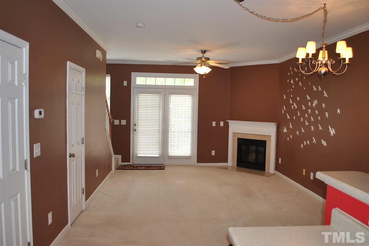 8234 Belneath Court Raleigh, NC 27613 - Photo 8 of 20 a view of a livingroom with a fireplace a chandelier and windows