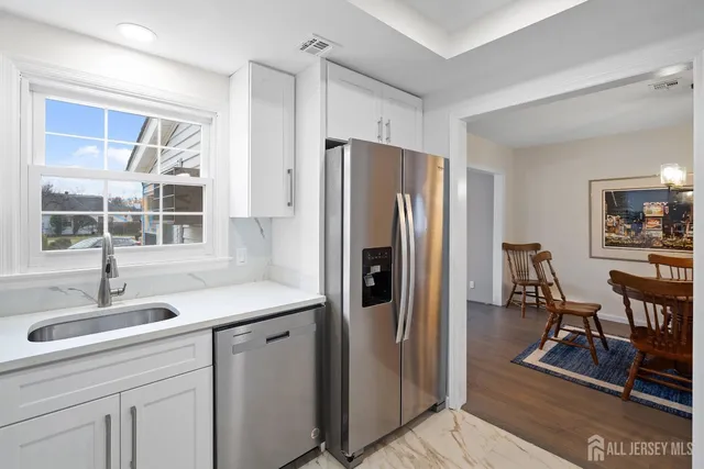 a kitchen with stainless steel appliances granite countertop a refrigerator and a sink