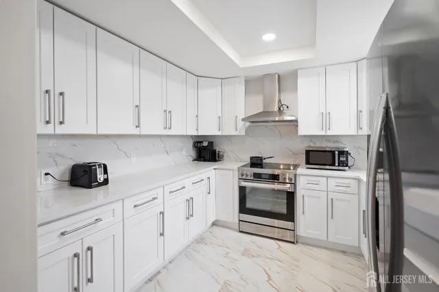 a kitchen with white cabinets and appliances