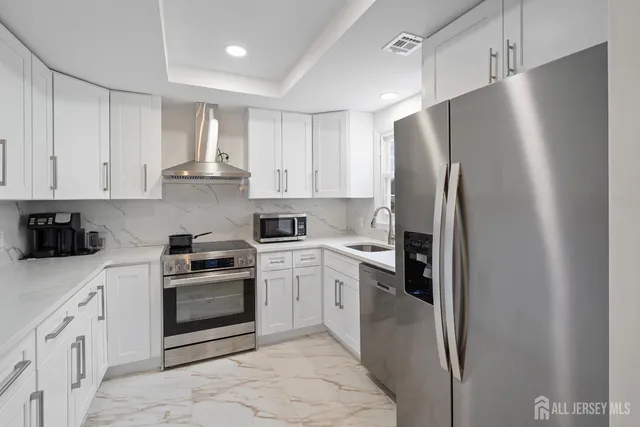 a kitchen with stainless steel appliances granite countertop a refrigerator sink and stove