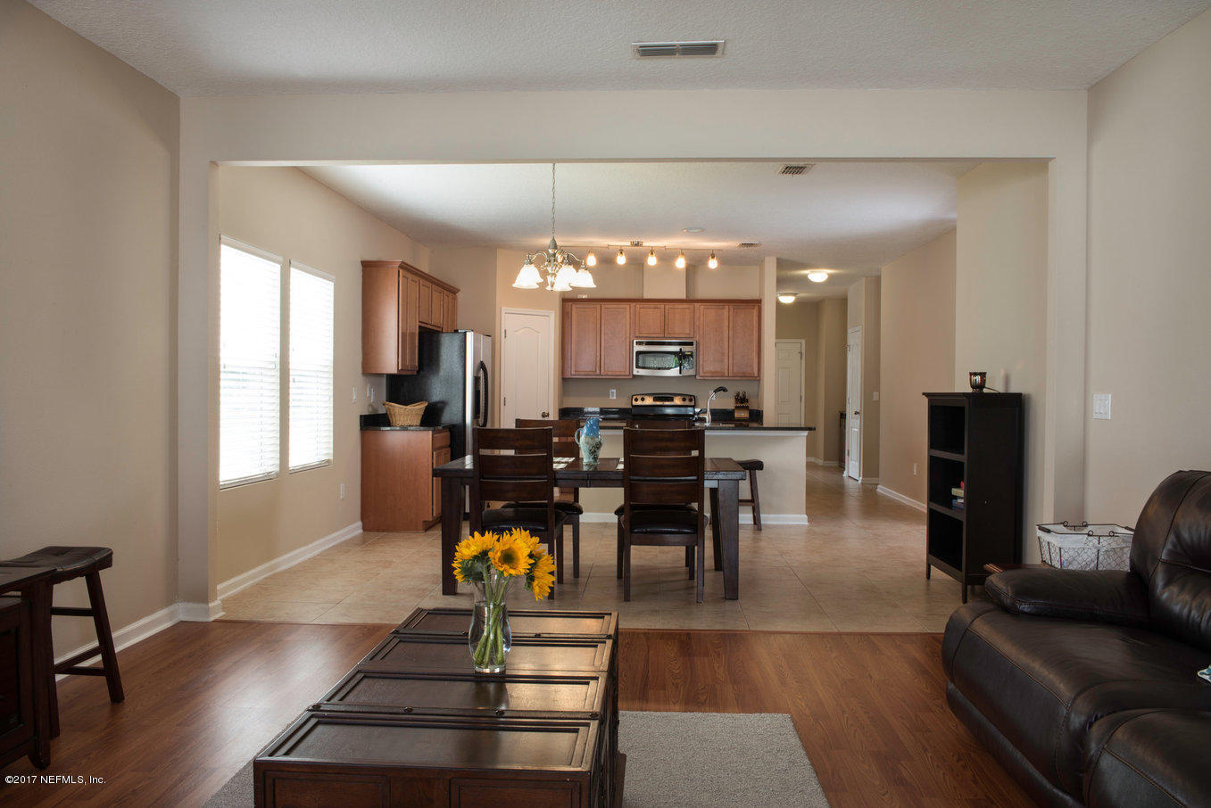 16365 Tisons Bluff Road Jacksonville, FL 32218 - Photo 6 of 25 a dining hall with couches a dining table and chairs with wooden floor