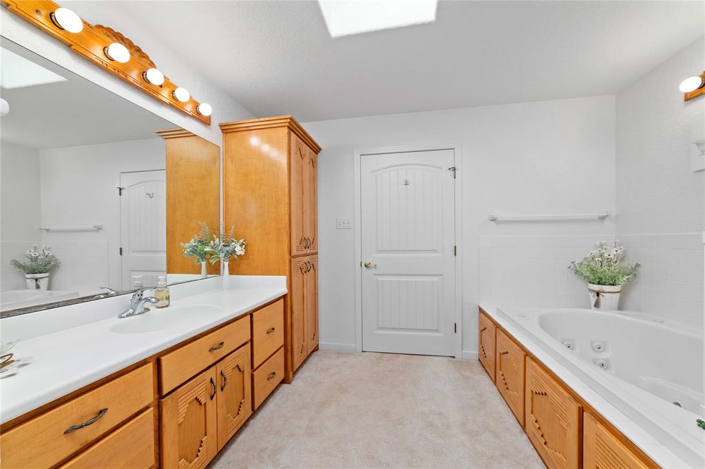 3612 Highway 1689 Comanche, TX 76442 - Photo 15 of 30 Full bathroom with vanity, a tub with jets, and a skylight