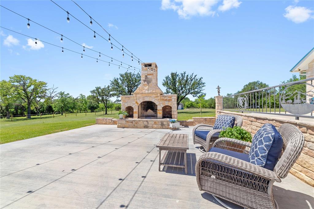 3612 Highway 1689 Comanche, TX 76442 - Photo 22 of 30 View of patio / terrace with an outdoor living space with a fireplace and view of wooded area