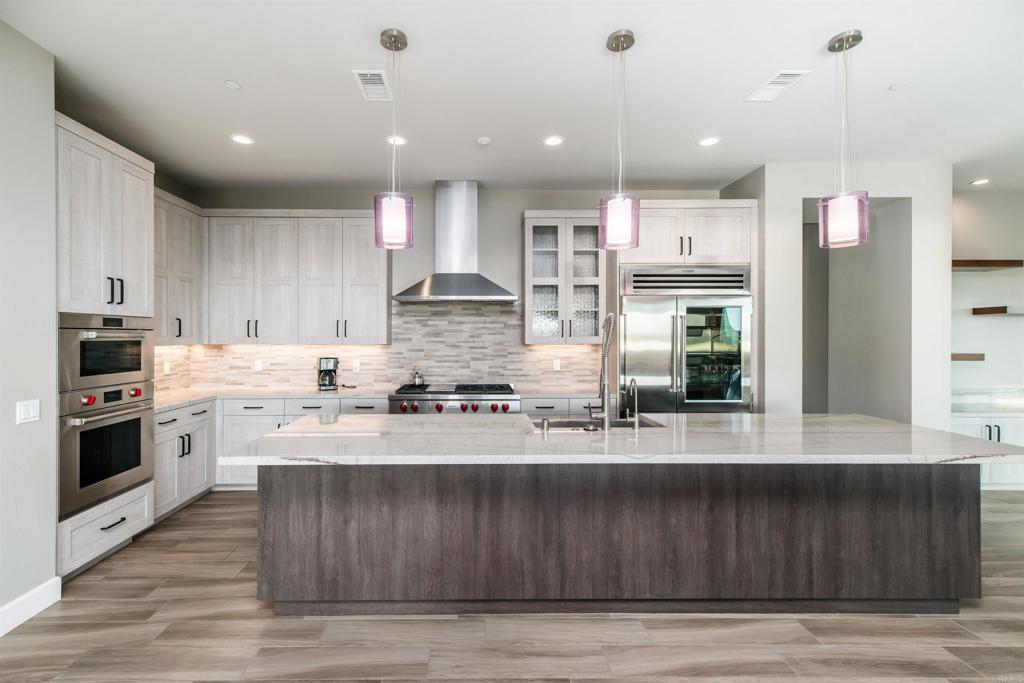 6768 Strawberry Place Carlsbad, CA 92011 - Photo 6 of 53 a kitchen with stainless steel appliances granite countertop a stove a sink and a refrigerator