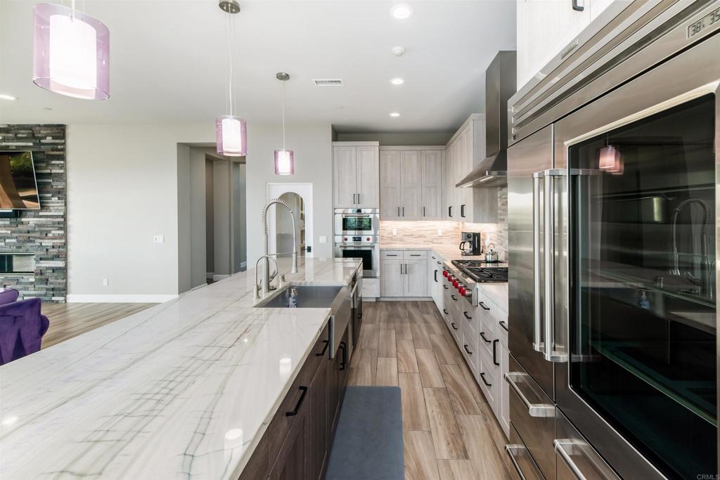 6768 Strawberry Place Carlsbad, CA 92011 - Photo 7 of 53 a large kitchen with a large counter top appliances and cabinets