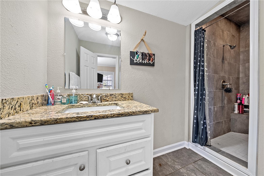 3600 Sanger Avenue Waco, TX 76710 - Photo 11 of 24 a bathroom with a granite countertop sink and a mirror