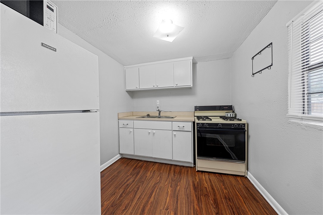 3600 Sanger Avenue Waco, TX 76710 - Photo 18 of 24 a kitchen with wooden floors and appliances