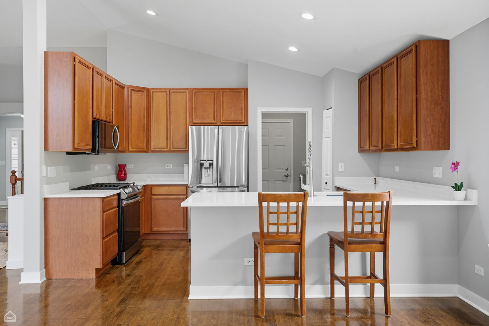 2008 Crooked Tree Court McHenry, IL 60050 - Photo 8 of 22 a kitchen with stainless steel appliances granite countertop a stove top oven a refrigerator a dining table and chairs with wooden floor