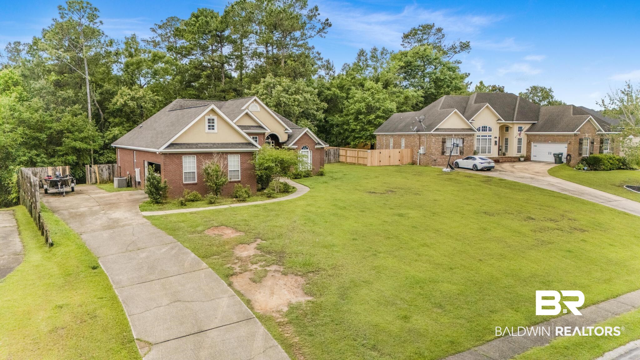 35814 Delvan Lane Bay Minette, AL 36507 - Photo 42 of 53 Brick exterior home with a gabled roofline and attached garage, featuring a paved driveway and manicured lawn