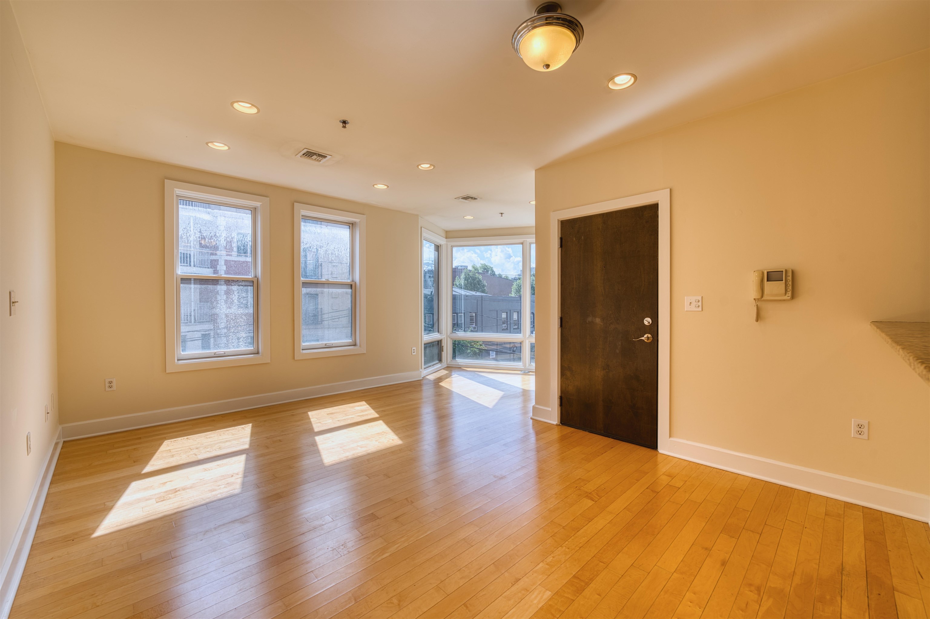 108 Jackson Street, Unit 3A Hoboken, NJ 07030 - Photo 12 of 30 a view of an empty room with wooden floor and a window