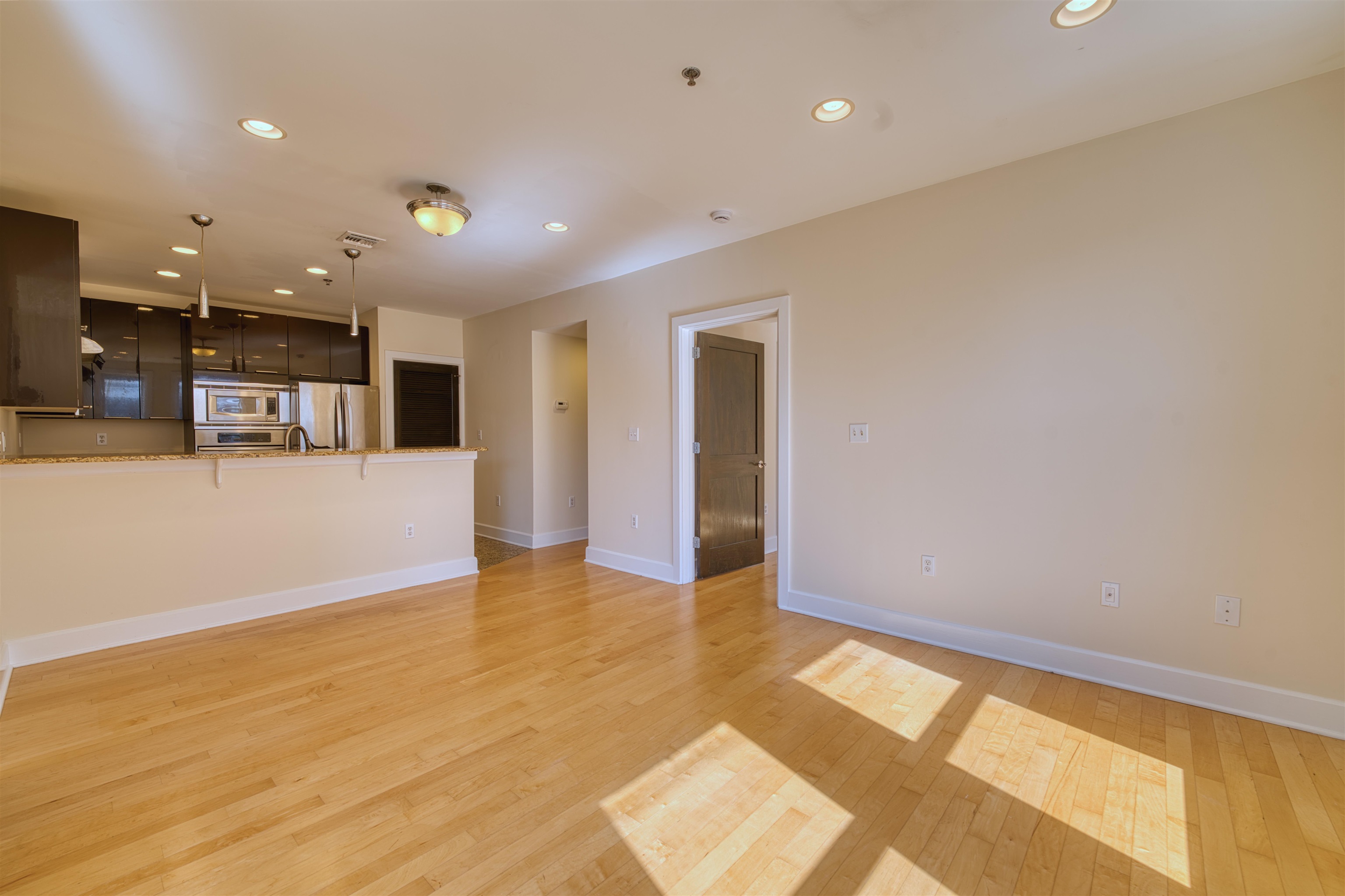 108 Jackson Street, Unit 3A Hoboken, NJ 07030 - Photo 13 of 30 a view of an empty room with kitchen and a window