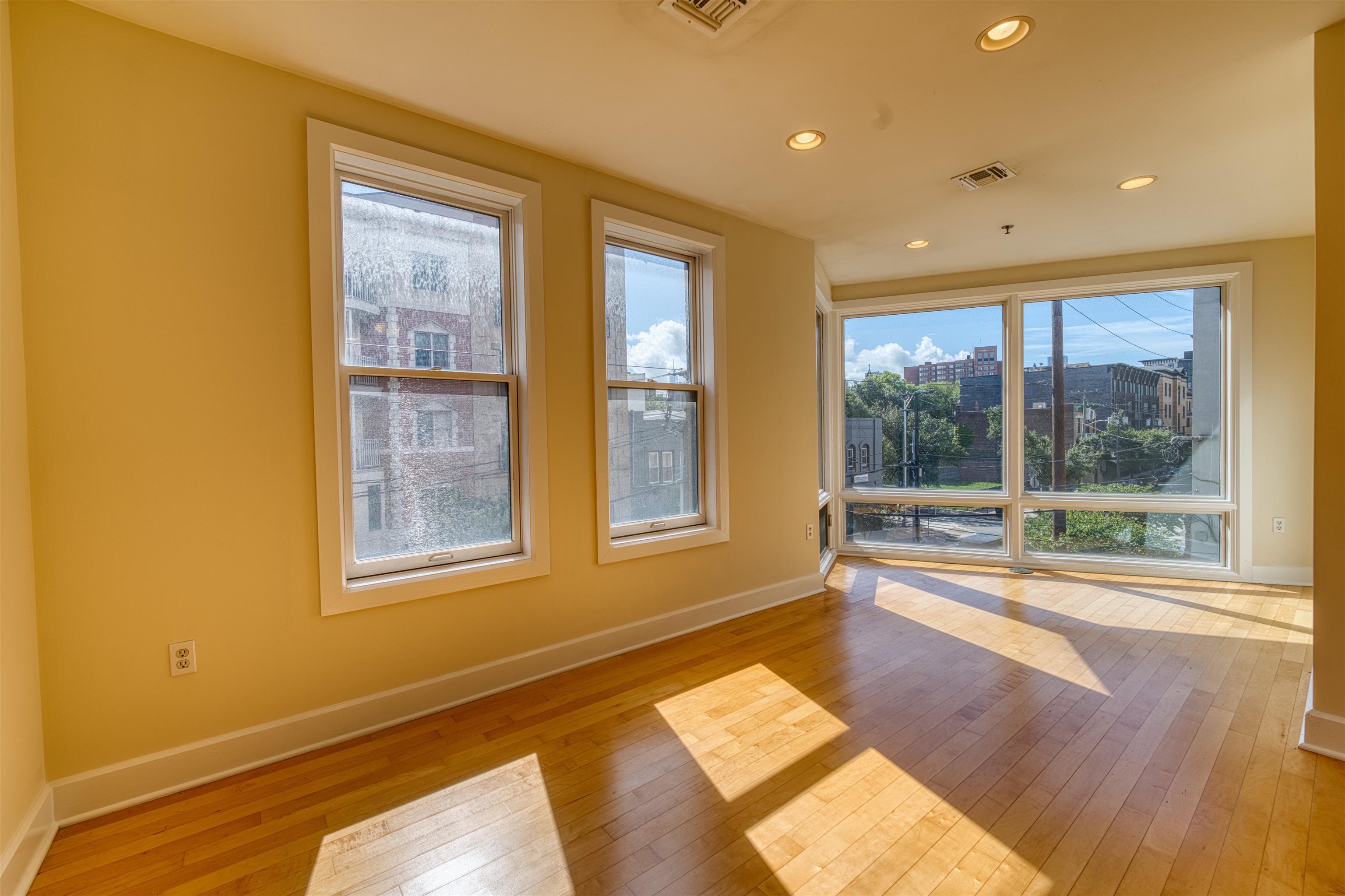 108 Jackson Street, Unit 3A Hoboken, NJ 07030 - Photo 22 of 30 a view of an empty room with a window and wooden floor