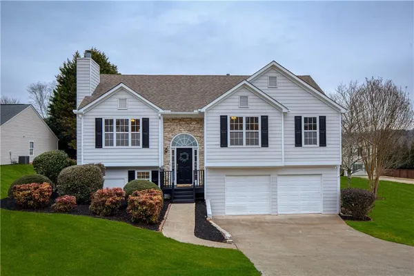 a front view of a house with a garden and yard