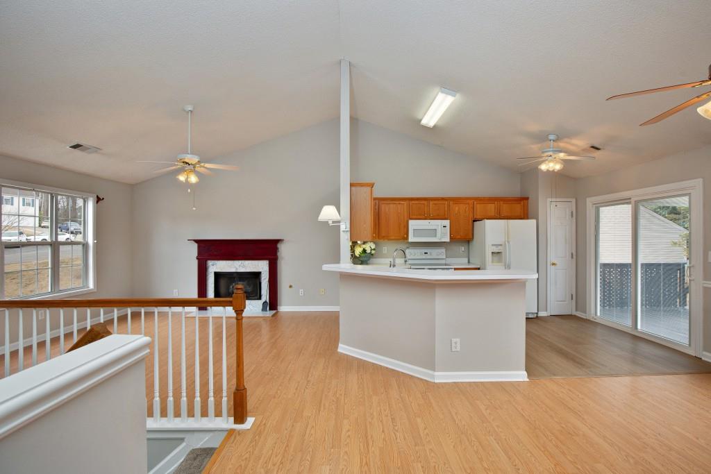 8440 River Bluff Place Ball Ground, GA 30107 - Photo 18 of 73 a living room with stainless steel appliances kitchen island a large kitchen island a stove a sink dishwasher and a fireplace with wooden floor