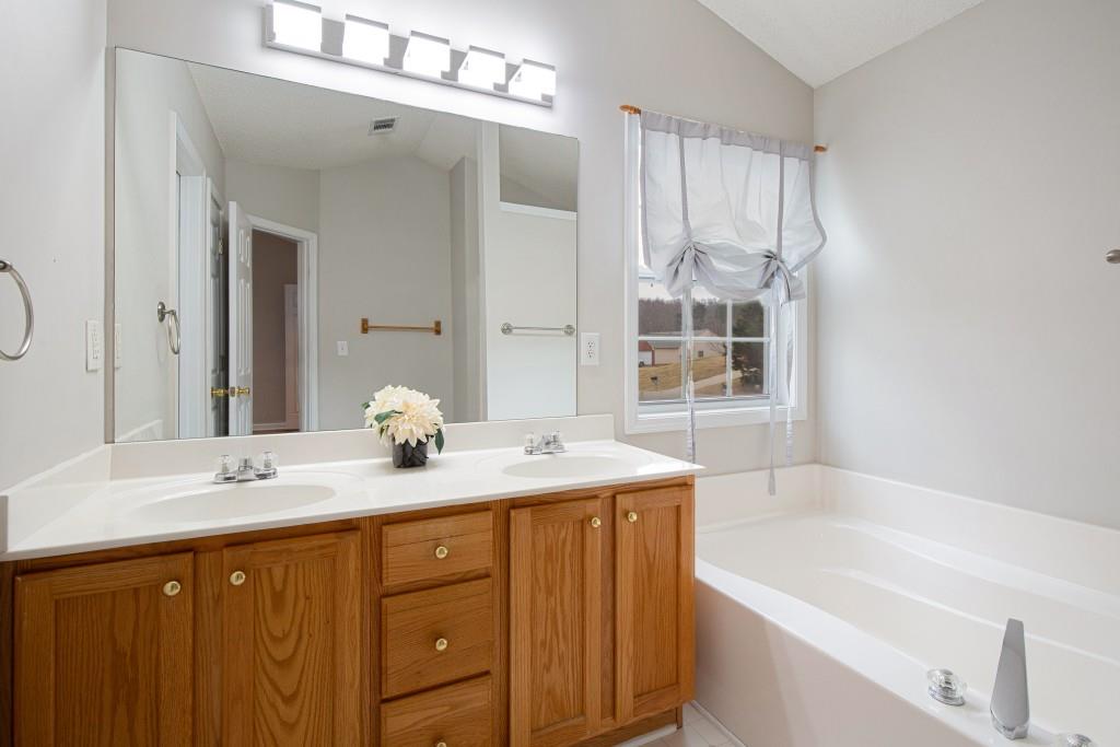 8440 River Bluff Place Ball Ground, GA 30107 - Photo 36 of 73 a bathroom with a granite countertop sink mirror and